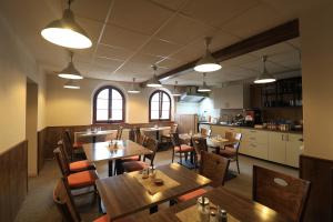 a restaurant with wooden tables and chairs and a kitchen at U Admirala in Kladno