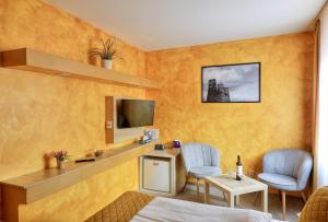 a room with a bed and two chairs and a tv at U Admirala in Kladno