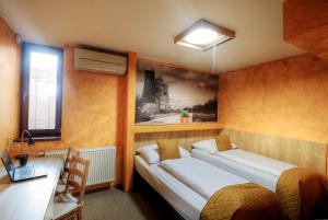 a bedroom with a bed and a desk with a laptop at U Admirala in Kladno