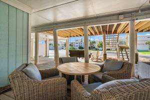 a patio with a wooden table and chairs and a table at Boardwalk Unit A4 in Pensacola Beach