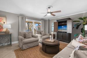 a living room with couches and a flat screen tv at Boardwalk Unit A4 in Pensacola Beach