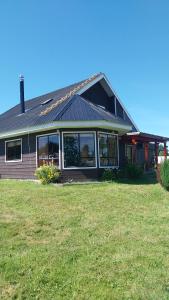 a house with a large lawn in front of it at Casa Halcon de Lagunitas in Puerto Montt