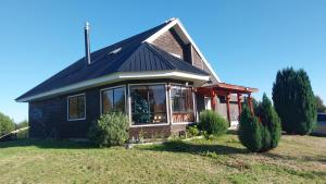 a house with a large window on a yard at Casa Halcon de Lagunitas in Puerto Montt +2 photos