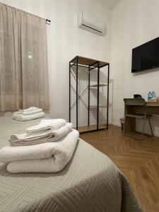 a room with a bed with white towels on it at Le casette apartaments in Torre Annunziata