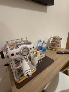 a robot is sitting on a table with cups at Le casette apartaments in Torre Annunziata