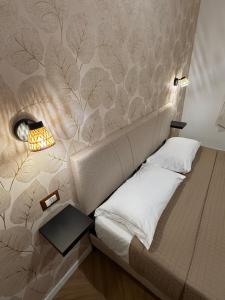 a bedroom with a bed with a wall covered in leaves at Le casette apartaments in Torre Annunziata