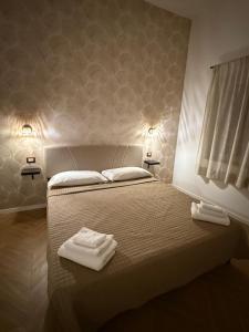 a bedroom with a bed with two towels on it at Le casette apartaments in Torre Annunziata +2 photos