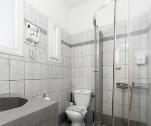 a bathroom with a toilet and a sink and a shower at Anemos Sea View in Batsi +51 photos