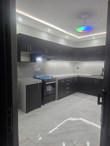a kitchen with black cabinets and a blue light at Newly Opened Mini Suite in Manta