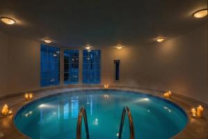 a large swimming pool in a room with candles in it at Black Dragon Haven Luxury Villa with Pool, Sauna & Jacuzzi in Prague
