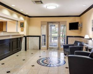 a living room with a couch and chairs and a tv at Suburban Studios Avondale in Avondale