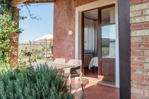 a patio with a table and chairs next to a brick building at Villa Del Sole in San Gimignano