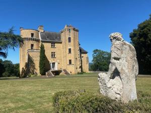 a castle with a statue in front of it at Château Blanat in Saint-Michel-de-Bannières