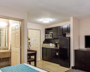 a small kitchen with a black refrigerator in a room at Suburban Studios Avondale in Avondale