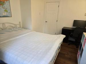 a bedroom with a bed and a desk with a computer at Hammond bay planta house in Nanaimo