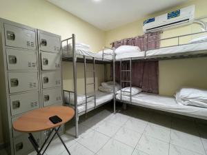 a room with three bunk beds and a table at United Holiday Homes in Dubai