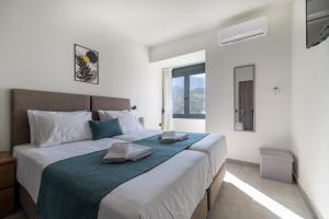 a bedroom with a large bed with two towels on it at AORA Asites Mountain View in Kato Asites +48 photos