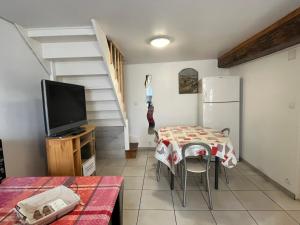 a living room with a table and a television and a staircase at Les Crus - Chablis in Courgis