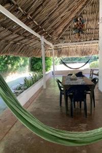 a hammock in a patio with a table and chairs at La Coralina azul in San Bernardo del Viento