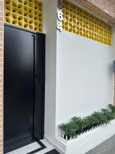 a black door on the side of a building with plants at Flat jk 05 térreo in Juazeiro do Norte