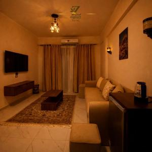 a living room with a couch and a tv at Zaytun Hotel Dahab in Dahab