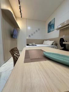 a large wooden table in a room with a bed at Flat jk 05 térreo in Juazeiro do Norte
