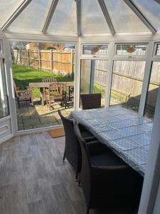a conservatory with a table and chairs and a patio at New Forest Home in Hordle