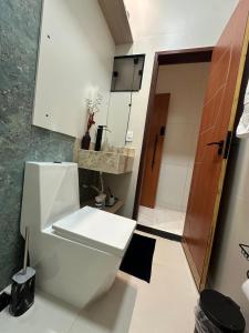a white bathroom with a toilet and a door at Flat jk 05 térreo in Juazeiro do Norte +24 photos