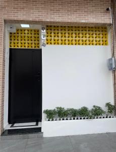 a black door on a brick building with plants at Flat jk 05 térreo in Juazeiro do Norte