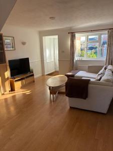 a living room with a couch and a table at New Forest Home in Hordle