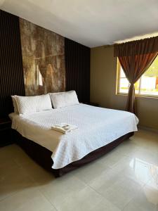 a bedroom with a bed with two towels on it at Hostal Casa Grande in Quito