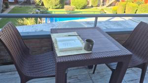 a table and two chairs with a book on it at Apartamentos del campus in Presidente Derqui +11 photos