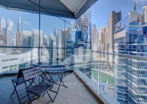 a balcony with two chairs and a view of the city at Staymora Suites in Dubai