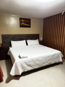 a bedroom with a large bed with white sheets at Hostal Casa Grande in Quito +4 photos