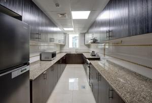 a large kitchen with marble counter tops and stainless steel at Staymora Suites in Dubai