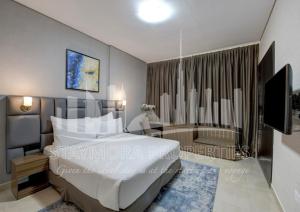 a bedroom with a large bed and a television at Staymora Suites in Dubai +39 photos