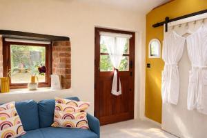 a living room with a blue couch and a door at Little Gem at Lough Sillan House - Adults only in Shercock