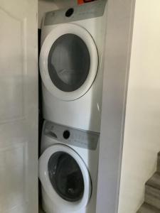 a bathroom with a toilet and a washing machine at Hammond bay planta house in Nanaimo