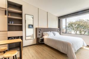 a bedroom with a bed and a window at Break Estudios Manizales in Manizales