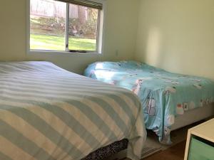 two beds in a small room with a window at Hammond bay planta house in Nanaimo +13 photos