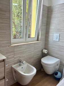 a bathroom with a sink and a toilet and a window at Villa sul mare di Cupra in Cupra Marittima +15 photos