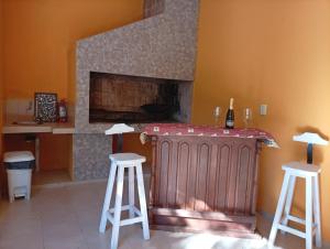 a living room with a fireplace and two stools at Celina in Chajarí