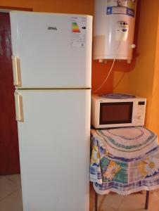 a white refrigerator in a kitchen with a microwave at Celina in Chajarí +4 photos