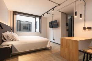 a bedroom with a bed and a window at Break Estudios Manizales in Manizales