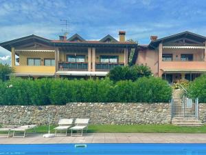 a large house with benches in front of a wall at Sunshine Luxury Apartment - spacious house - Lake View - Pool in Padenghe sul Garda