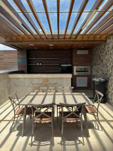 a table and chairs on a patio with a kitchen at STUDIO CALHAU 907 Vista mar in São Luís