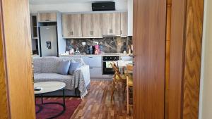 a kitchen and a living room with a couch and a table at Lemon Garden Apartment-Hot Tub Jacuzzi in Gjirokastër