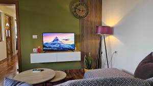 a living room with a flat screen tv on a wall at Lemon Garden Apartment-Hot Tub Jacuzzi in Gjirokastër