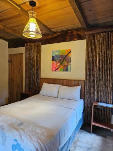 a bedroom with a large white bed and a lamp at Nawal in Lanquín +63 photos