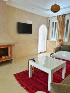 a living room with a white table and a fireplace at Mirleft Horizon Apartments in Mirleft